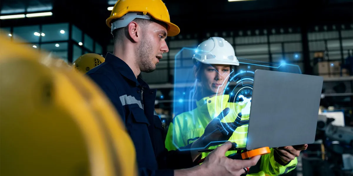 Zwei Mitarbeiter in Schutzkleidung unterhalten sich über die Maßnahmen, die die KI zum Arbeitsschutz vorgeschlagen hat. © Adobe Stock, Kannapat