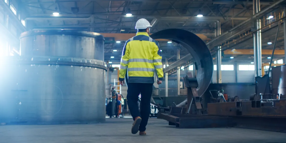 Mitarbeiter trägt Schutzkleidung. Das Arbeitsschutzgesetz bildet die Grundlage für wichtige Schutzmaßnahmen am Arbeitsplatz. © Shutterstock, Gorodenkoff