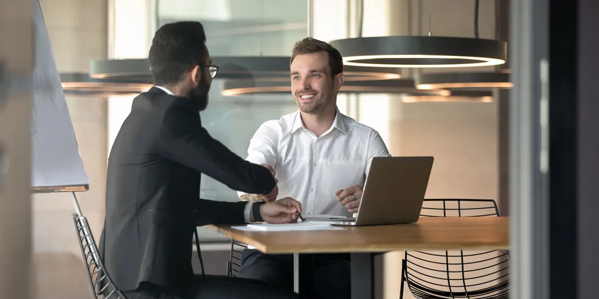 Unternehmer und Arbeitnehmer führen ein erfolgreiches Mitarbeitergespräch. © Shutterstock, fizkes