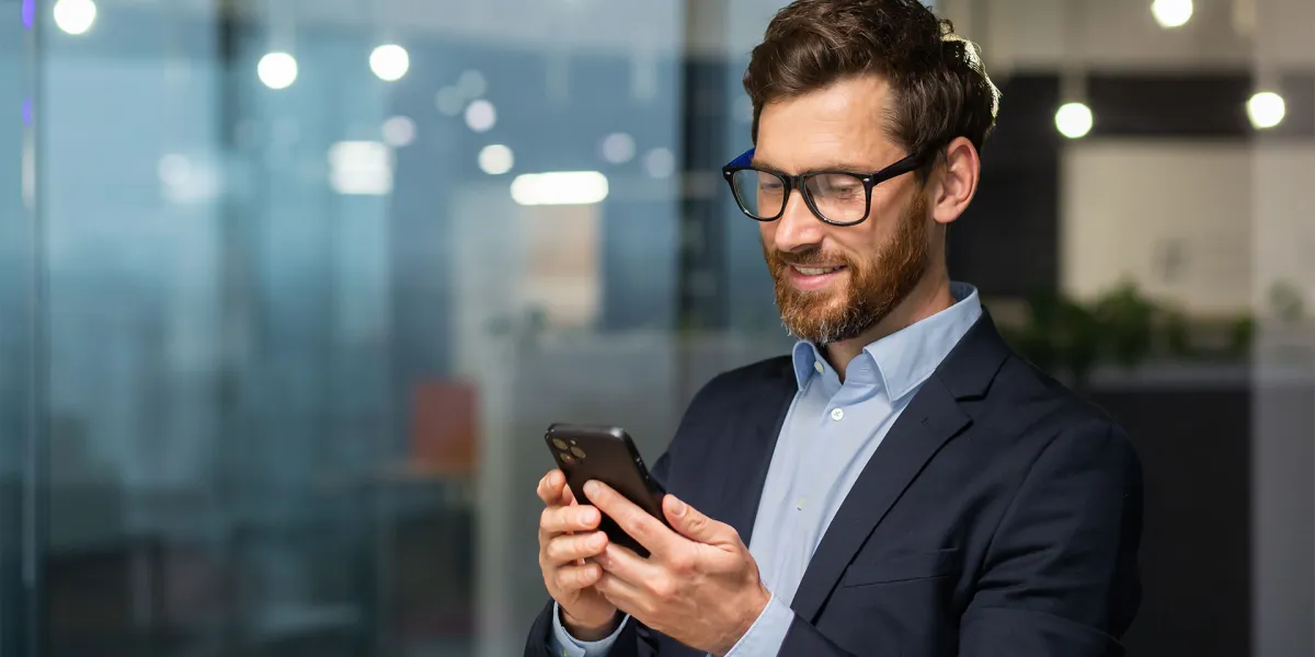 Mann, der sich auf dem Handy über die Änderungen 2025 für Unternehmer informiert. © Adobe Stock, Liubomir