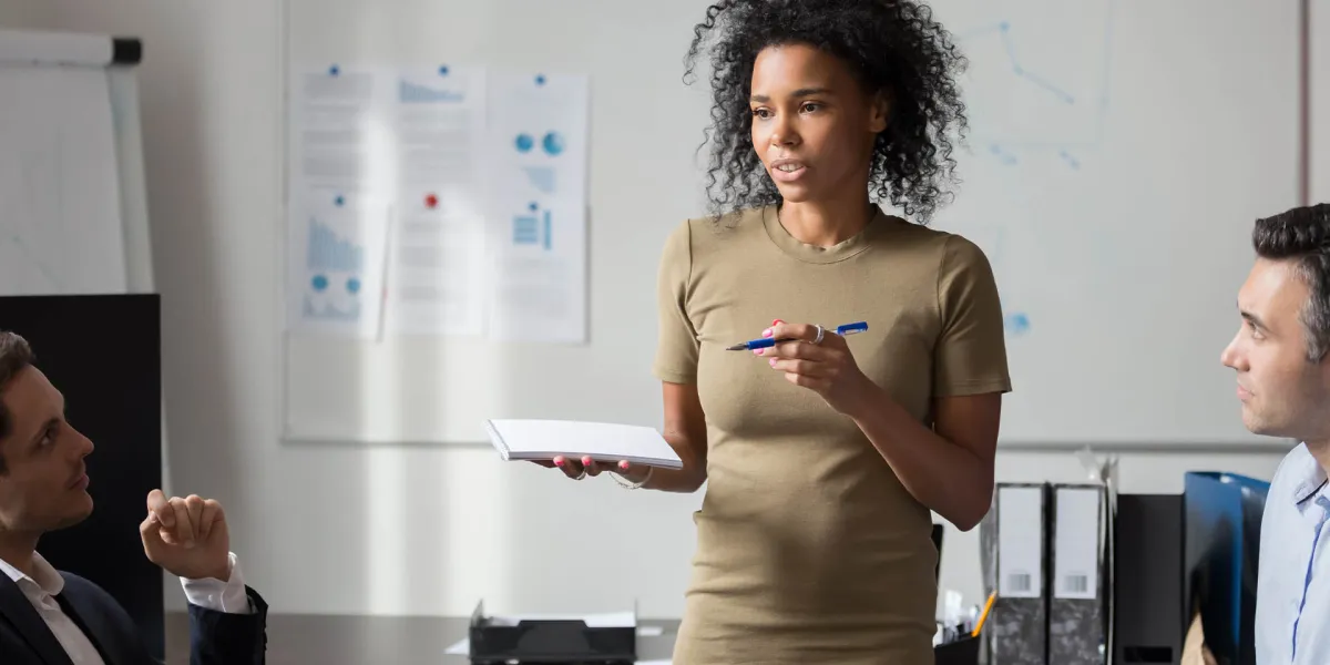 Unternehmerin erklärt Mitarbeitern die DGUV Vorschriften. Arbeitgeber müssen viele Gesetze und Regeln für den Arbeitsschutz beachten. © Shutterstock, fizkes